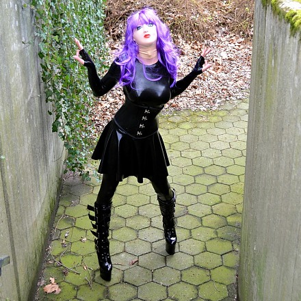 Black Latexdoll poses outside