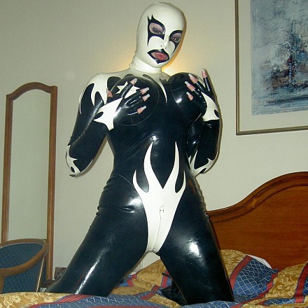 Blonde Fetish Amateur In A Black And White Latex Catsuit Poses On Her Bed